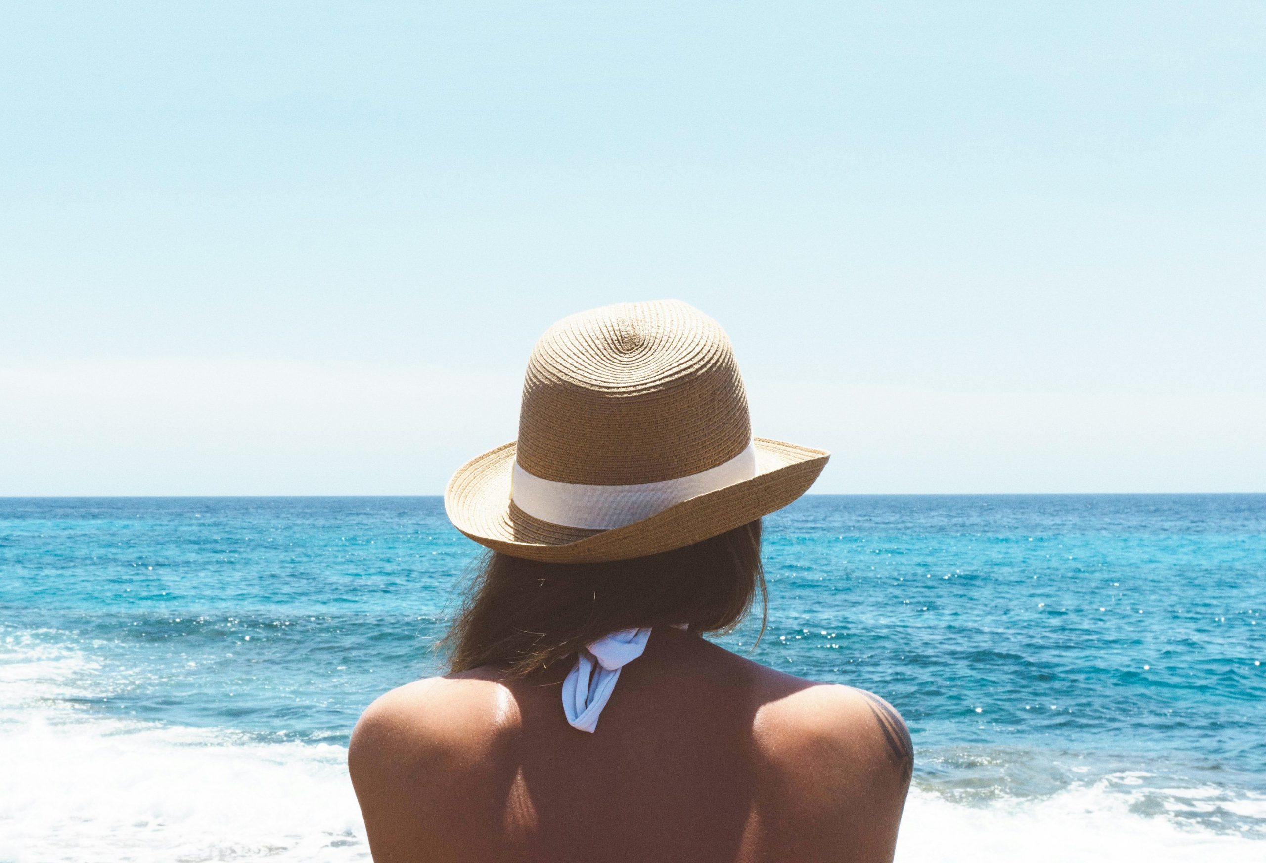 Chica con un sombrero en la playa